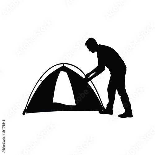 Silhouette of a Man Pitching a Tent for Outdoor Camping Adventure