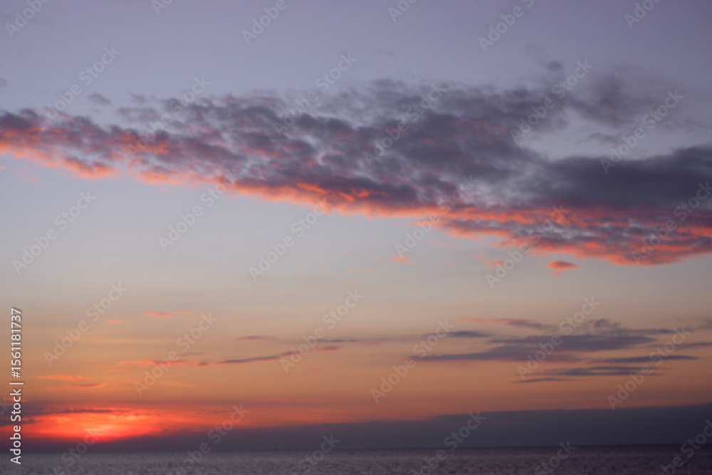 sunset in the sea. Beautiful colorful sky and cloud in twilight time background. Orange fluffy clouds and sun sunlight reflection in the blue sunset in the sea. Beautiful colorful sky and cloud in twilight time background. Orange fluffy clouds and sun sunlight reflection in the blue