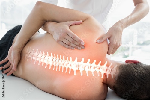 Highlighted spines of injured man having massage