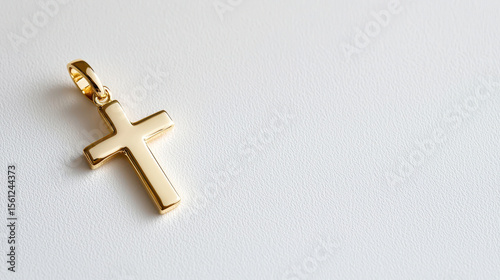 Elegant gold cross pendant on smooth surface, symbolizing faith and spirituality, perfect for personal adornment or gifting
