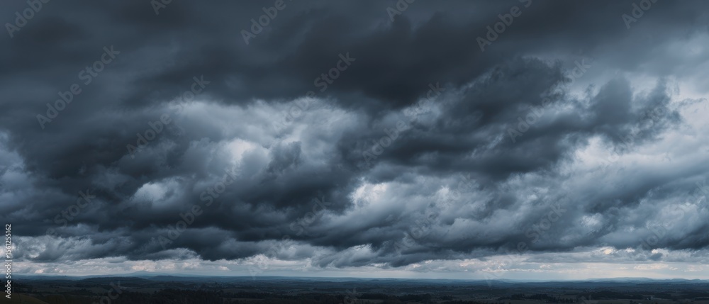 Obraz premium The dramatic storm clouds rolling across an expansive landscape.