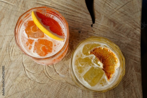 Fotografia Top view of two fruity cocktails on a wooden table