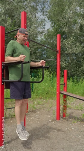 Athletic 63 year old senior man doing outdoor sports. Abdominal exercise.