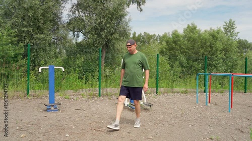 Elderly man exercising outdoors. Fitness and strength for seniors. Dips on bars.
