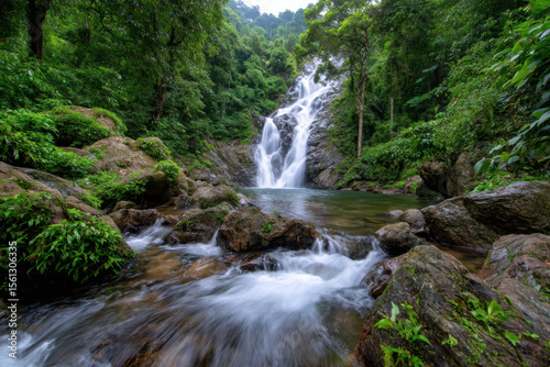 Majestic waterfall cascading into a serene pool surrounded by lush greenery