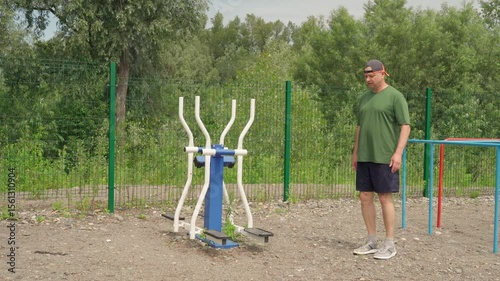 Elderly man on the sports ground. Healthy aging. Exercise for developing leg muscles.