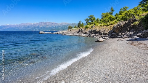 Serene pebble beach meets crystal-clear turquoise water under a vibrant blue sky, backed by lush greenery and distant mountains