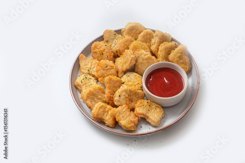 Breaded chicken nuggets with sauce and salad on a plate on a white background