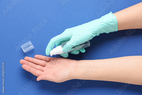 Woman applying sanitizer on...