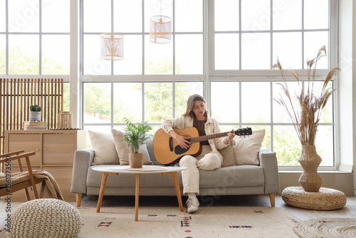 Young woman playing guitar ...