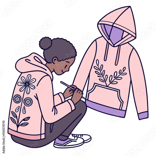 Young person customizing a pink hoodie with floral designs and drawing tools