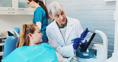 Child, explain and dentist with teeth on tablet for screen, extraction information and diagnosis. Dentistry, girl kid and mature woman in practice for dental implant and tooth alignment procedure