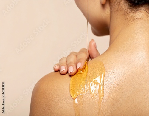 Woman applying nourishing oil to her skin using a glass eye dropper. 