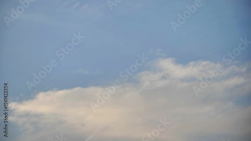 White contrail from a jet plane flying high in the blue sky