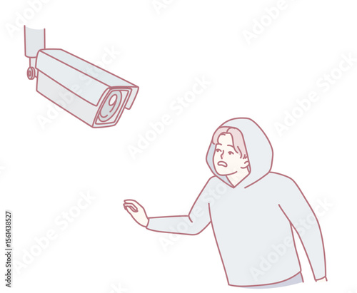 A figure in a hoodie interacts with a surveillance camera, highlighting security and privacy themes.