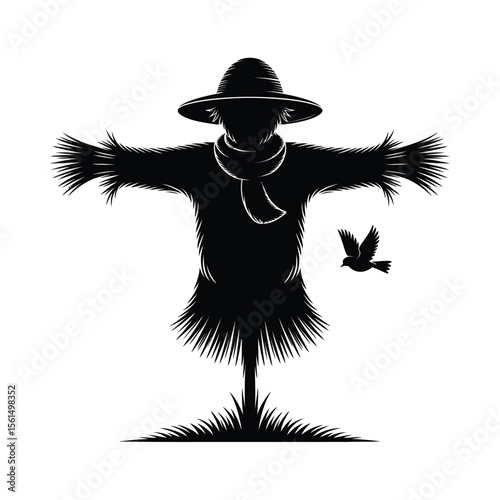 Scarecrow silhouette with a bird flying nearby in the field