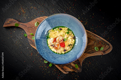 Creamy seafood risotto with shrimp, mussels, and calamari on a dark background. Elegant Italian rice dish.