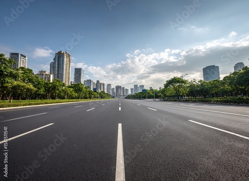 High-speed highway, an asphalt road with trees and buildings in the background. The wide-open plain is empty of cars on an early summer day. In the front view, white lines mark the right side for driv