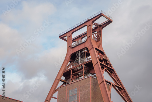Low angle view of Zollverein Coal Mine Industrial Complex tower with cloudy blue sky background, Essen, Germany