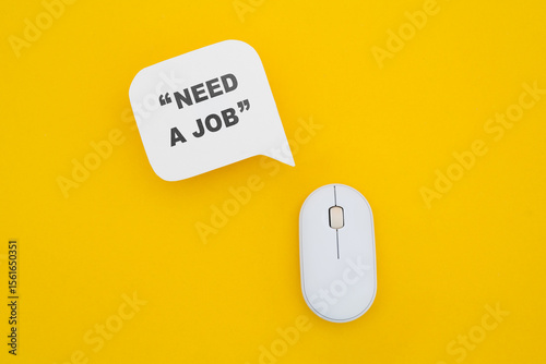 real white speech bubble paper cut with NEED A JOB in quotation marks and computer mouse on yellow background