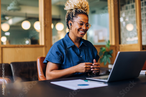 Smiling woman having a video call in a casual business setting