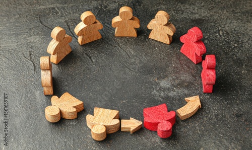 Wooden figures in a circle, with one group singled out, suggesting exclusion or isolation