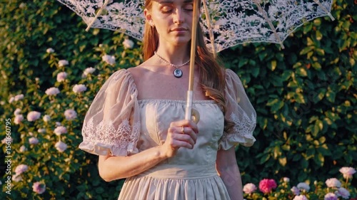woman in garden with lace parasol, Young woman in vintage dress holding lace parasol in blooming garden at sunset. Surrounded by flowers and greenery. Concept of romantic era, elegance, and femininit