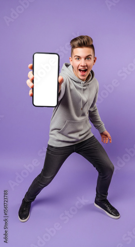 Trendy Teenager Making a Fun Face and Holding a Smartphone with a Blank Screen for a Social Media App Mockup