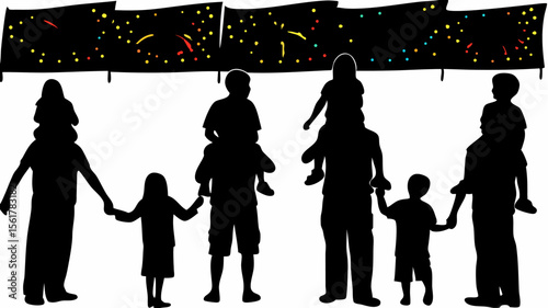 Silhouette of families at an outdoor event with a decorated banner in the background at night time