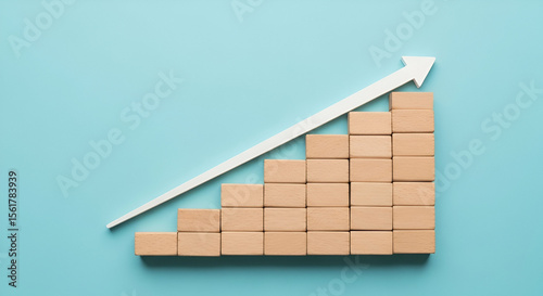 Wooden Blocks Forming a Growth Chart with White Arrow on a Blue Background Illustrating Business Success and Financial Progression