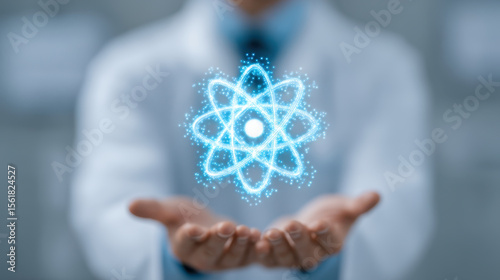 Atomic energy concept with glowing blue atom symbol floating above open hands of scientist in lab coat