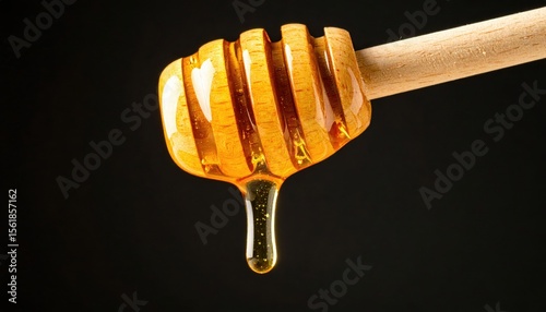 Close-up of honey dripping from a wooden dipper against a dark background, highlighting its texture