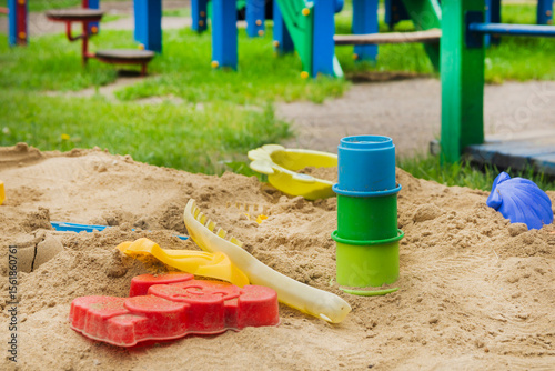 Empty children's sandbox with colorful toys. Children's recreation in summer. Playground for children