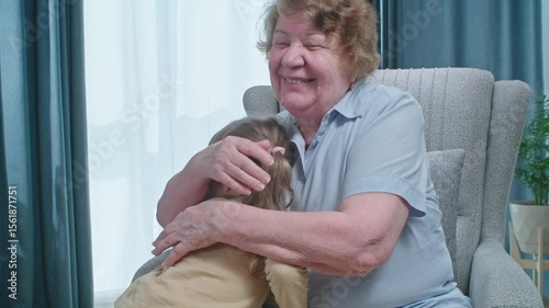 Senior woman with tremor hugging her little granddaughter, happiness when you got people that care about you