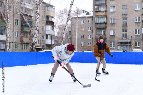 Canvas Print People skate and play ice hockey in the yard