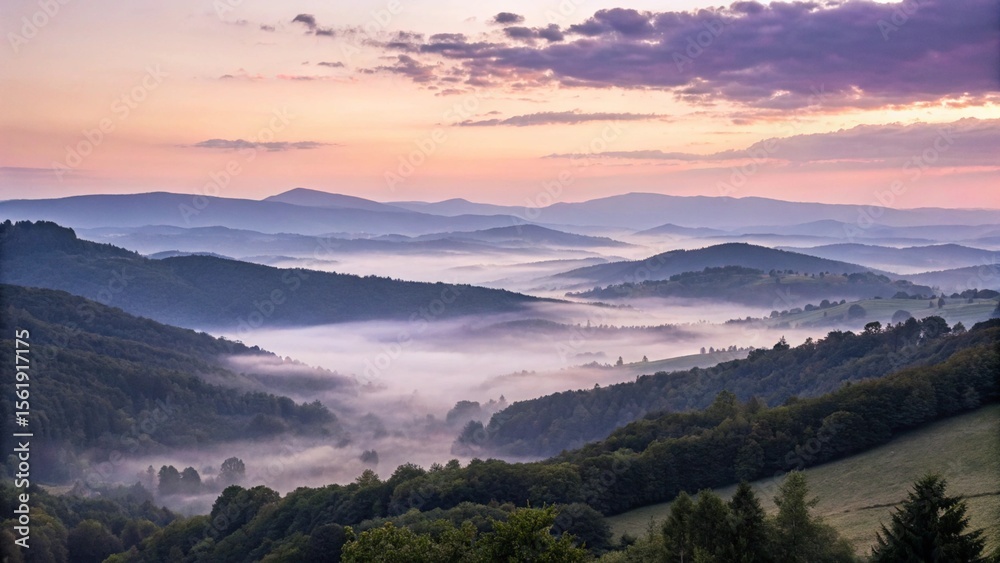 Fototapeta premium A scenic view of mountains and valleys shrouded in fog at sunrise