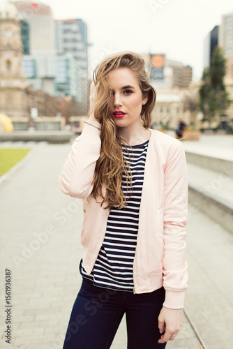 Young woman with striped shirt posing in the city