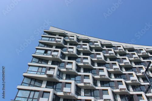Newly built and ready for occupancy house with a roof design similar to a trampoline. Geometric Architecture of Multi Storey Apartment House