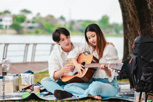 Asian Couple Playing Guitar Outdoors