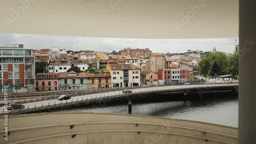 Urban view with colorful old and new buildings by the riverside, the cars crossing the bridge — blending history, movement, and architectural rhythm, geometry, lines, brutalism, exterior, landscape