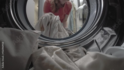 Female loading clothes into washer drum