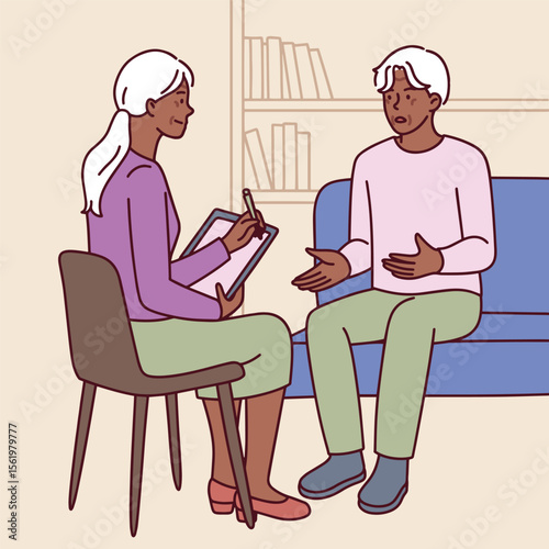 Dark skinned elderly man and woman sit indoors with books talking calmly during therapeutic conversation with psychologist