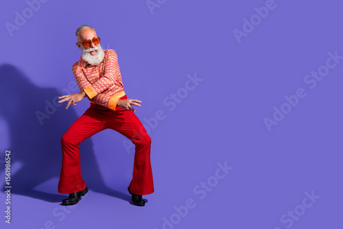 Wall Mural Happy man dancing in retro outfit with vintage elegance against a purple backgro