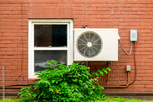 Canvas Print mini split air conditioner / heat pump exterior unit mounted on the brick wall o