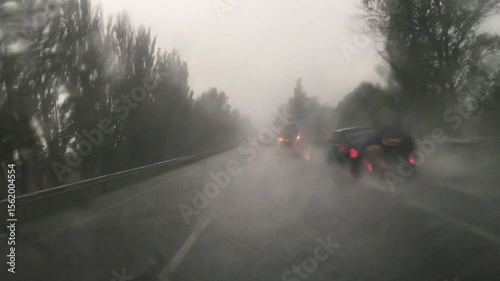Driving in heavy rain. Driver's point of view of driving on rural road in rainstorm. 