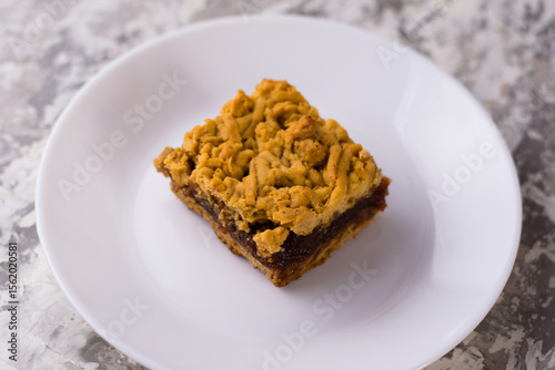 Delicious homemade pie with apple jam. A crispy piece of grated pie with jam on a plate, the aroma of apple and cinnamon