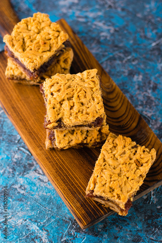 Delicious homemade pie with apple jam. Crispy pieces of grated pie with jam on a wooden board close-up, apple and cinnamon aroma