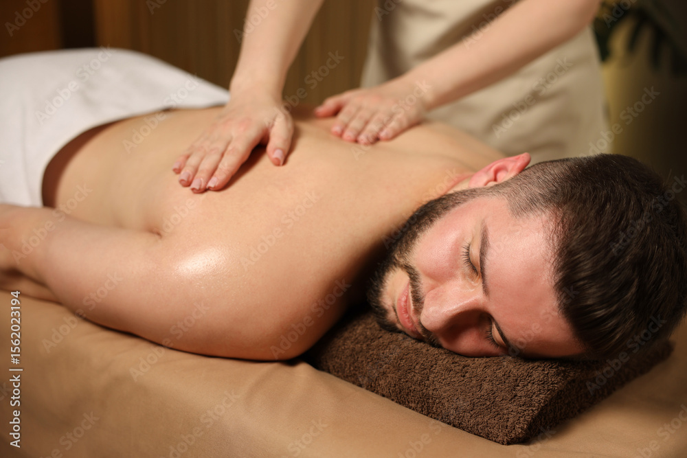 Man receiving relaxing massage in spa salon Man receiving relaxing massage in spa salon
