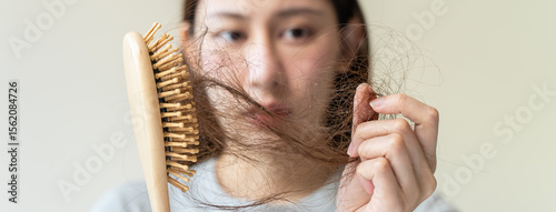 Close-up young woman brushing her hair and have many hair loss on the comb