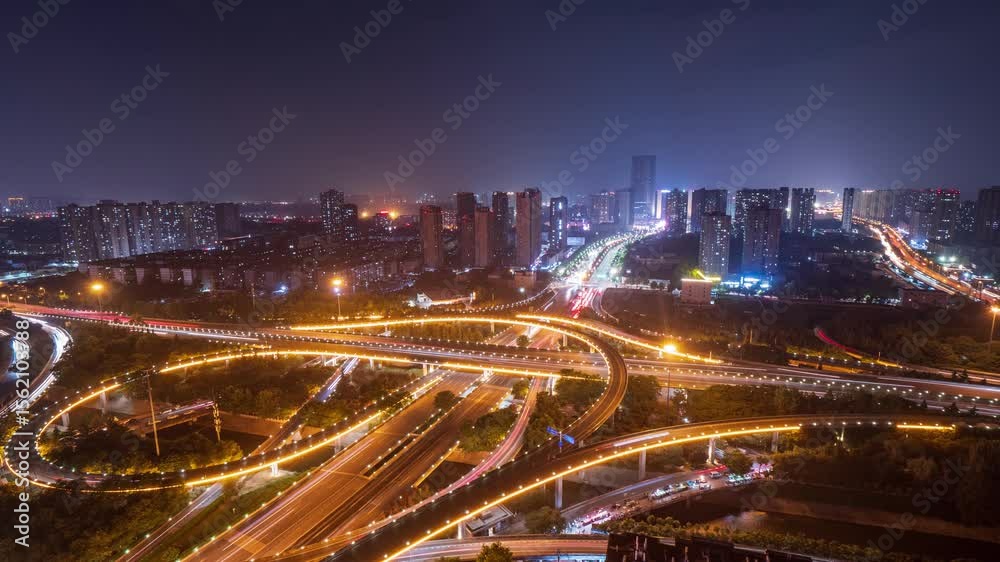 Night view of bustling interchange captured in dynamic timelapse showing vibrant city lights and traffic flow